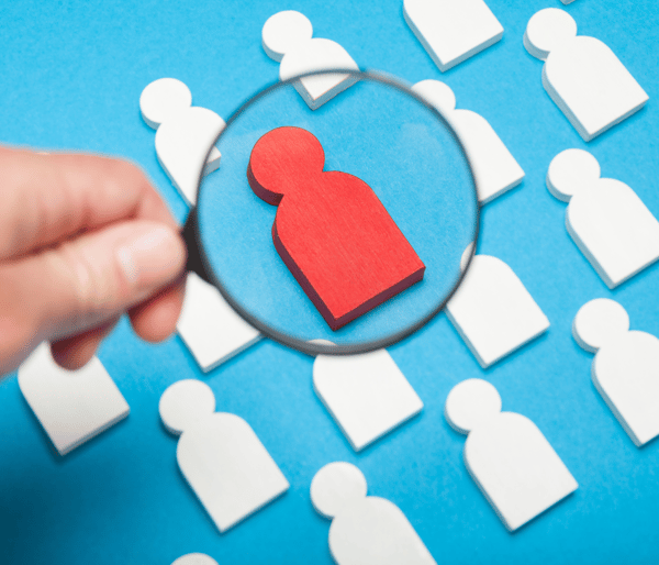 Hand with a magnifying glass over a selected candidate